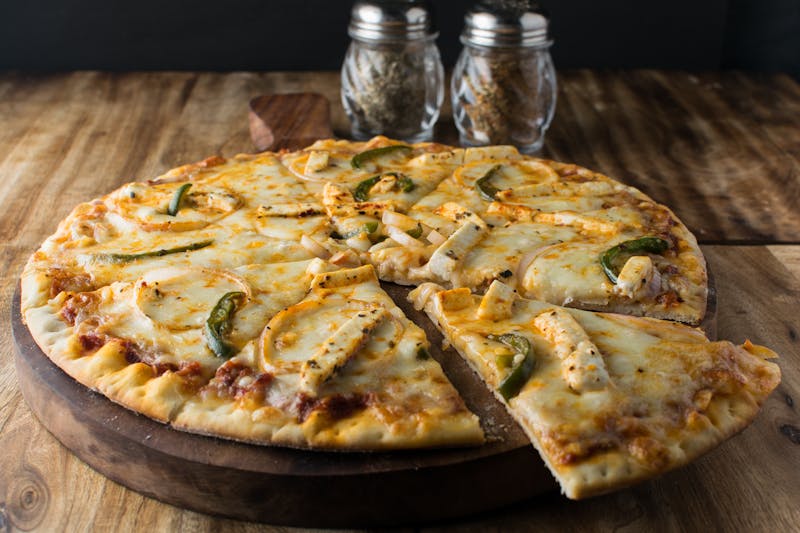 fresh pizza toppings and ingredients spread on wooden table